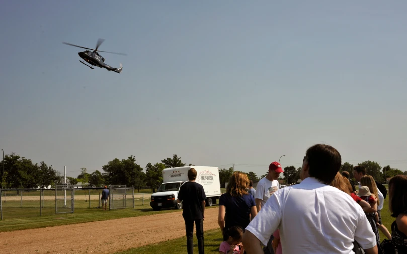 people watch an object in the air as it flies over them