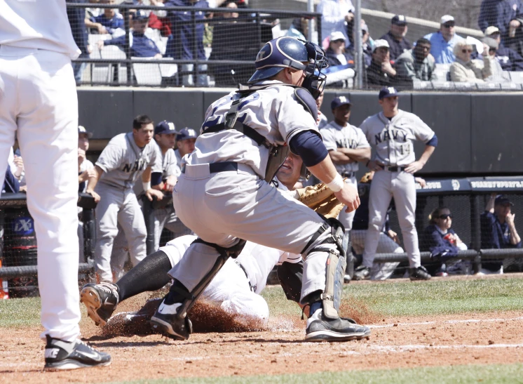 a baseball player slides into home base during a game