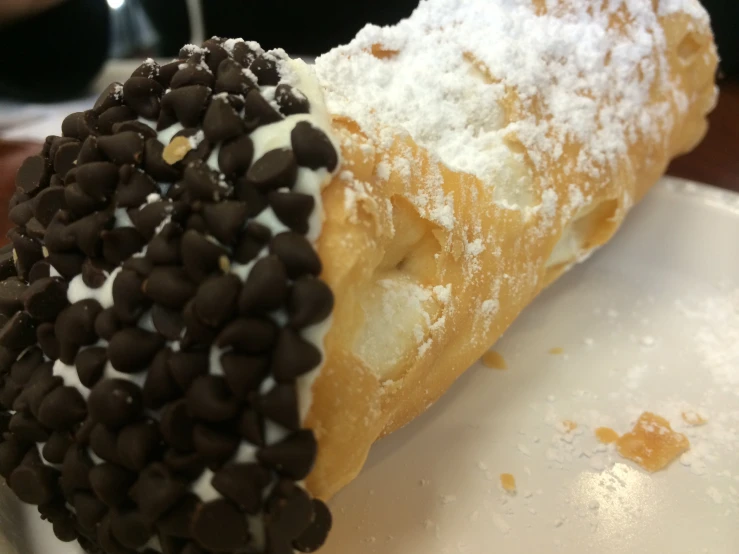 a donut covered in chocolate chips and powdered sugar