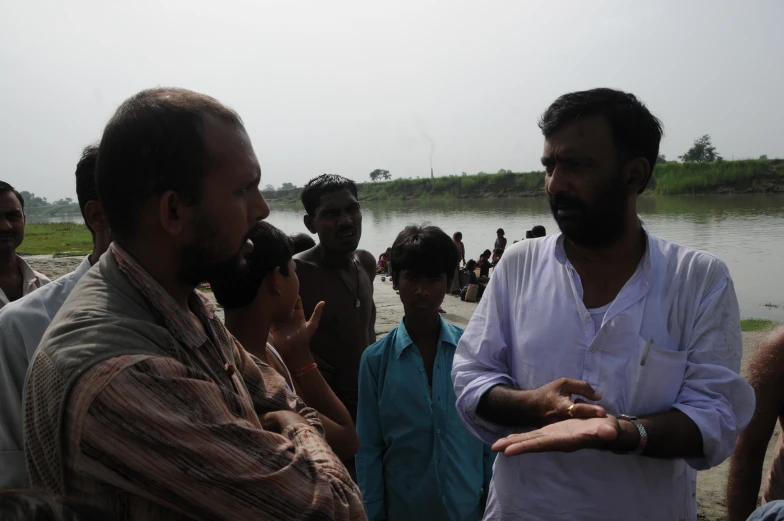 men talking to each other on the shore by water