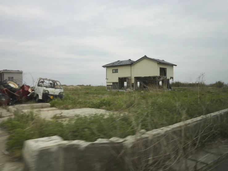 some trucks and house on the grass and dirt