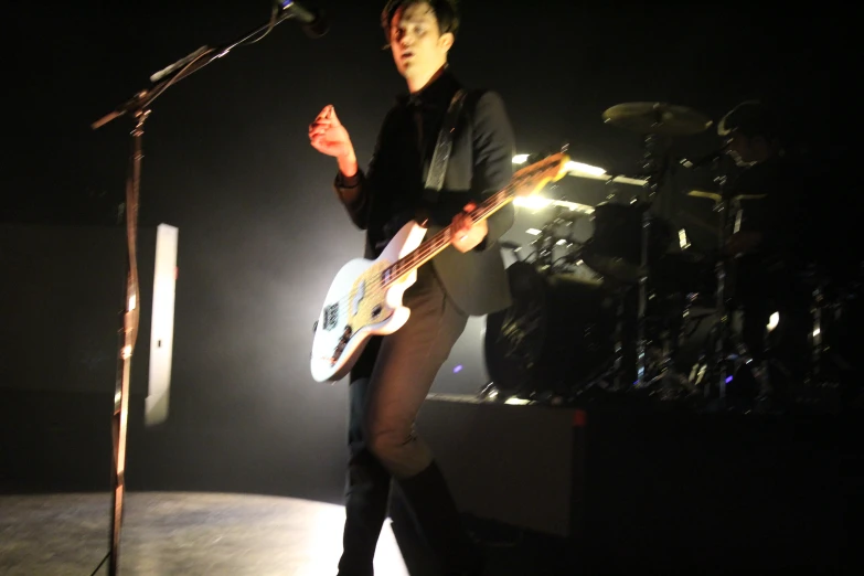 a man in black shirt playing guitar on stage