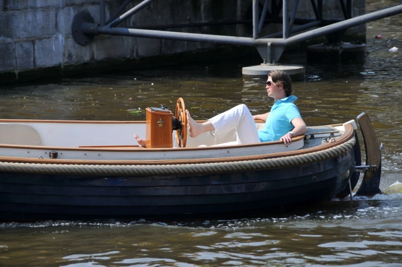 a man sitting in the front of a wooden boat