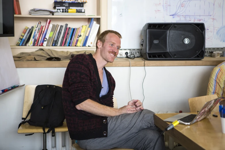 a man sitting on a chair next to a computer