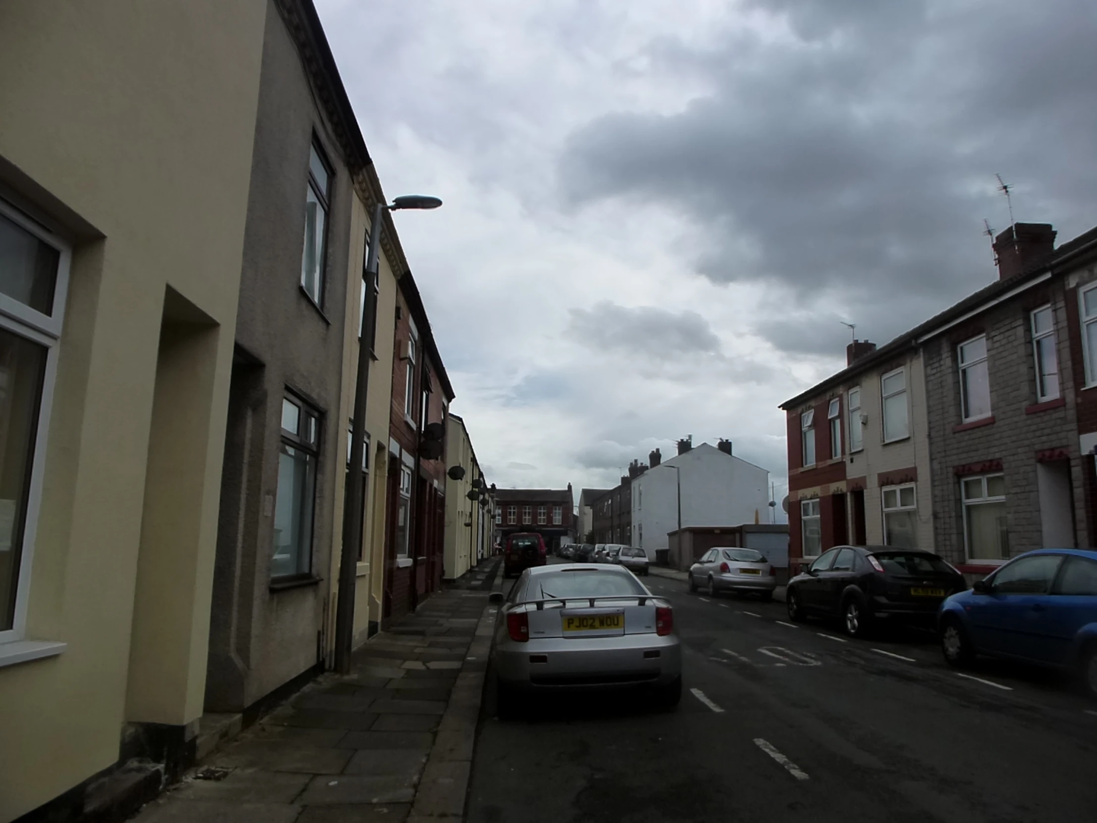 cars parked in the street by some buildings