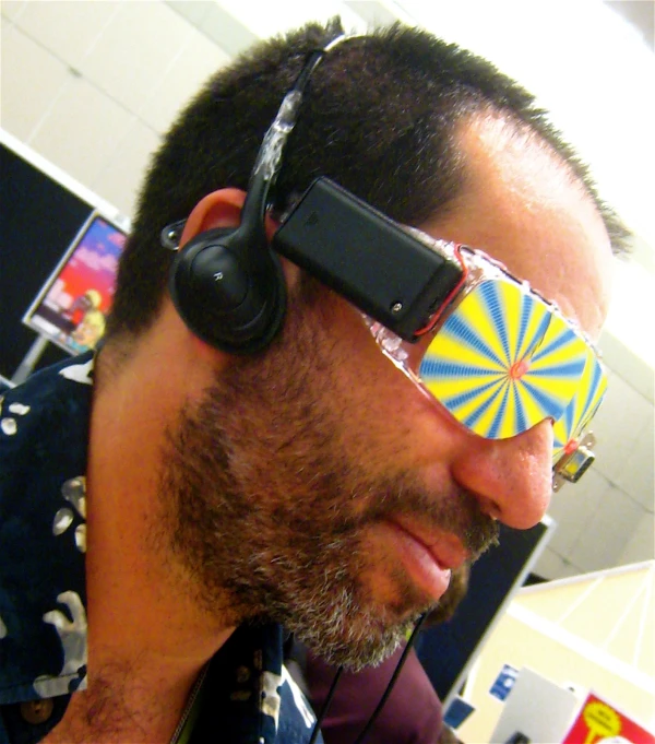 a man wearing headphones while looking through a paper cut in half
