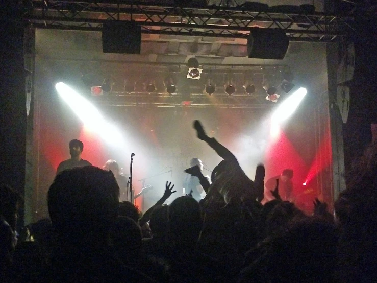 a large crowd with their arms up and lights on