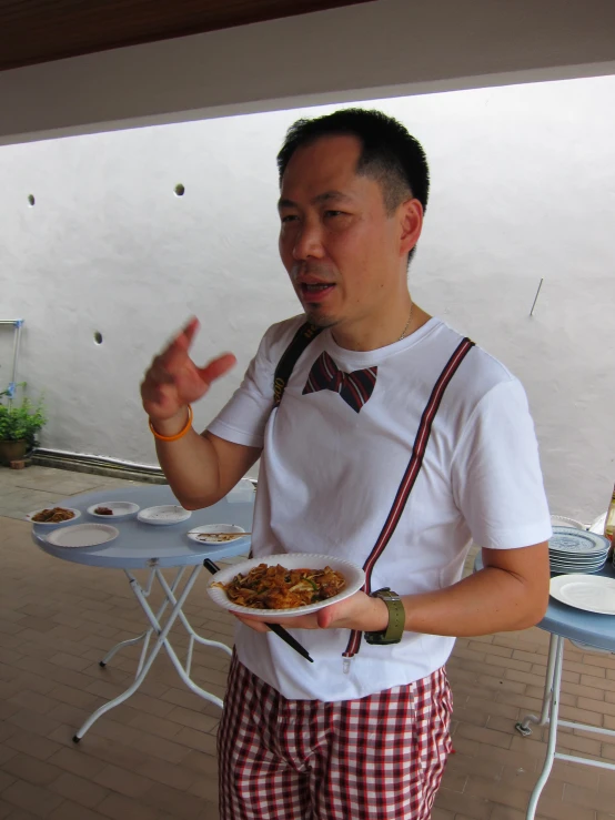 an asian man holding a plate of food