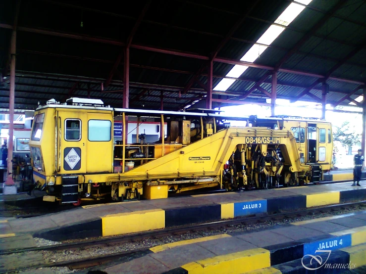 a yellow train sits inside of a building