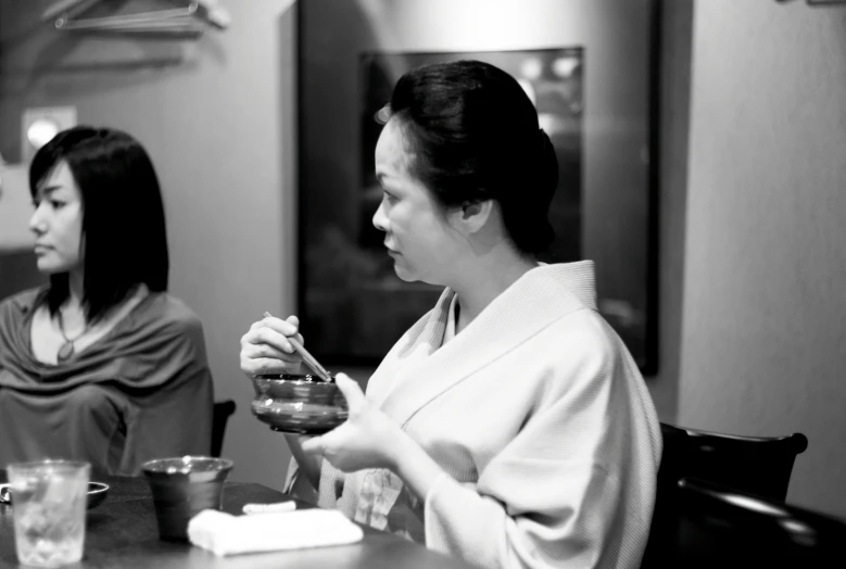 two women are sitting at a table eating