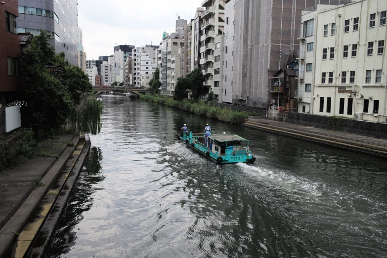 two people ride in a small boat down a river