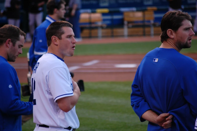 a man is talking to other baseball players