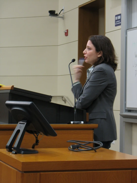 the woman is talking at the microphone at the podium