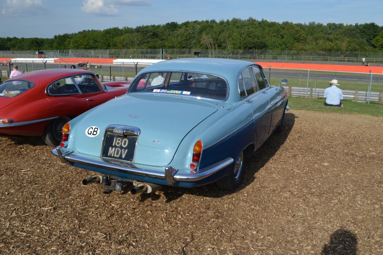 two old cars in the dirt near each other