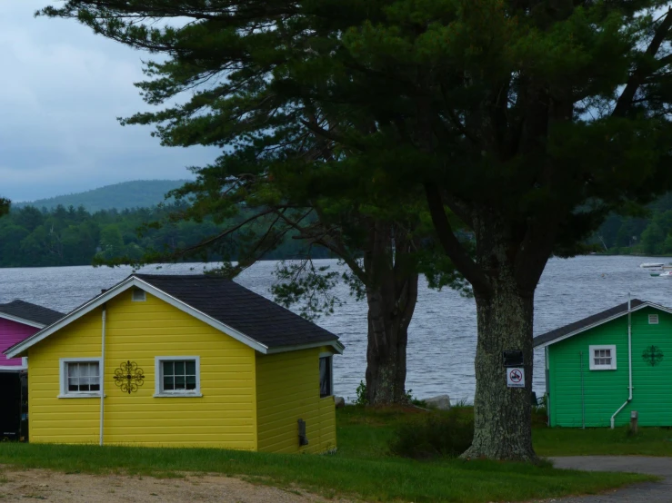 three different colored houses sitting near water