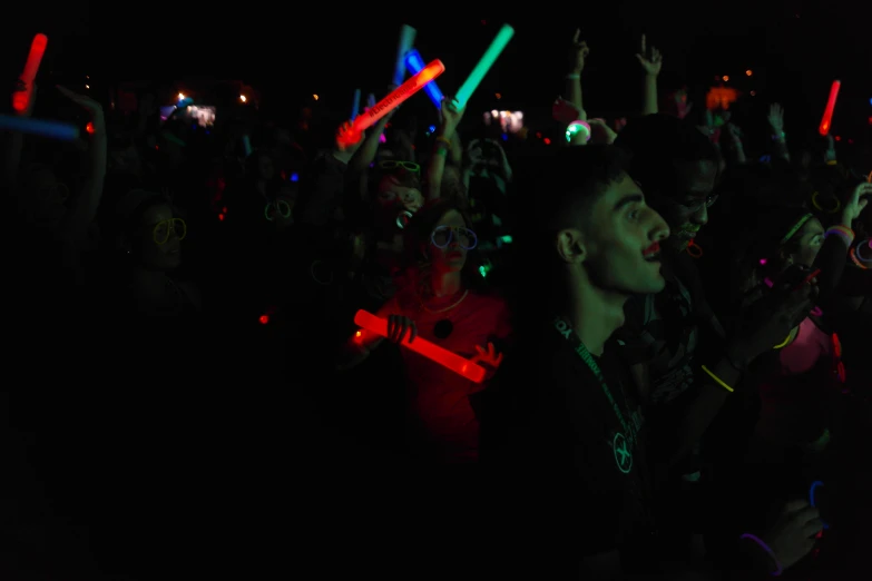 a crowd of people watching a laser light show