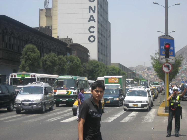 a bunch of cars driving down the street in front of tall buildings