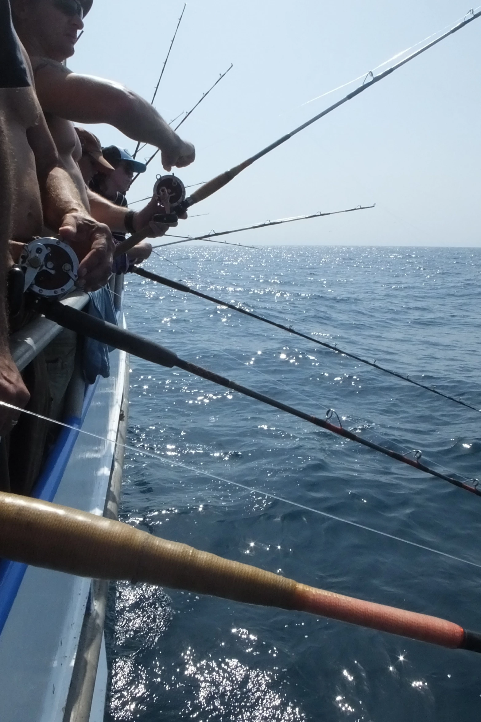 two men who are on a boat with some fishing rods