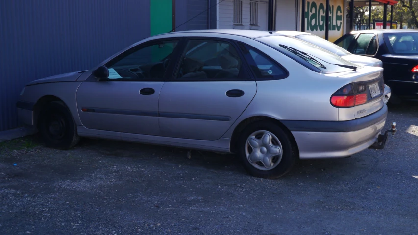 a silver car parked near a building in a parking lot