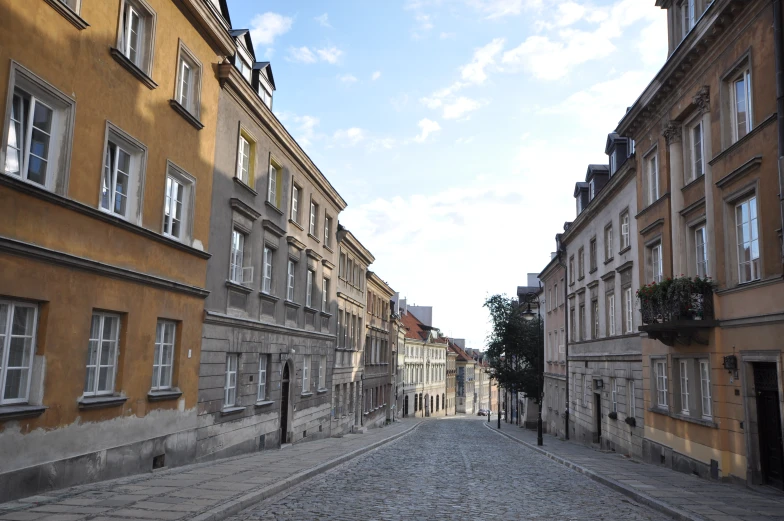 a cobblestone street runs between two buildings