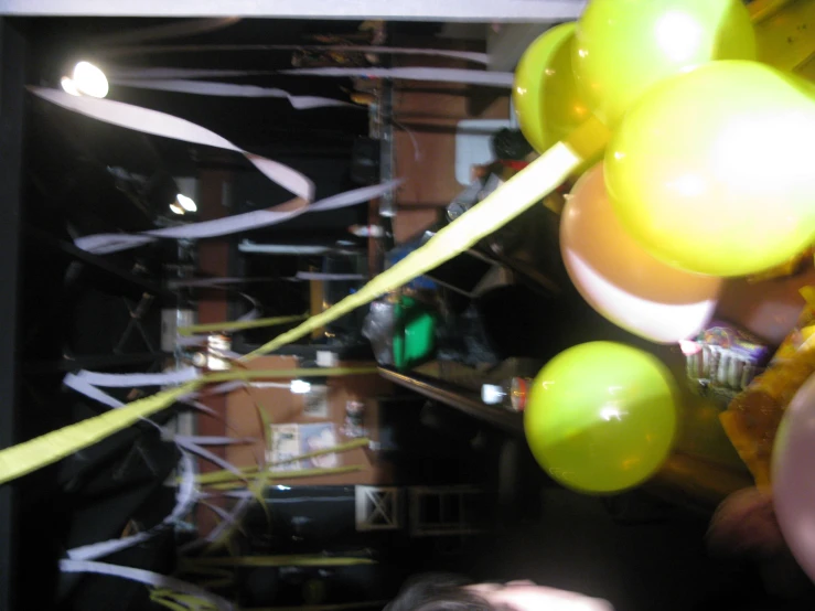 some yellow and green balloons are hanging from strings