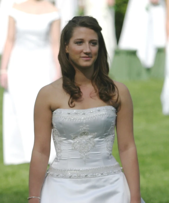 a young woman dressed in a long white dress