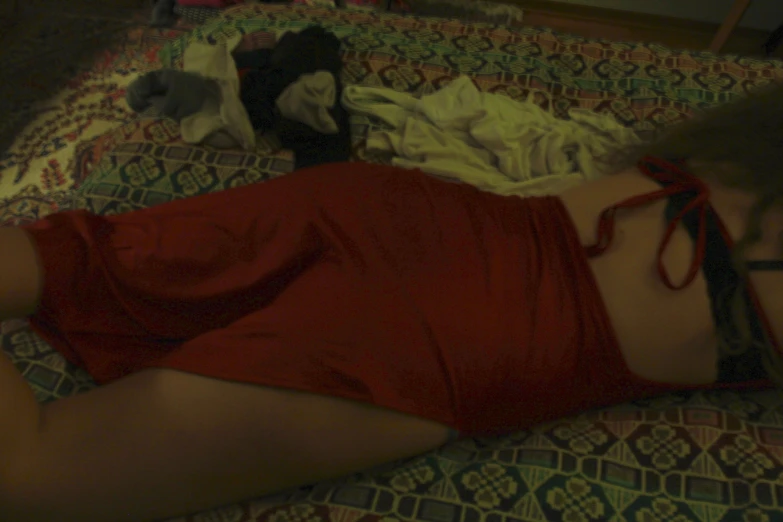 a woman lies on the ground wearing red