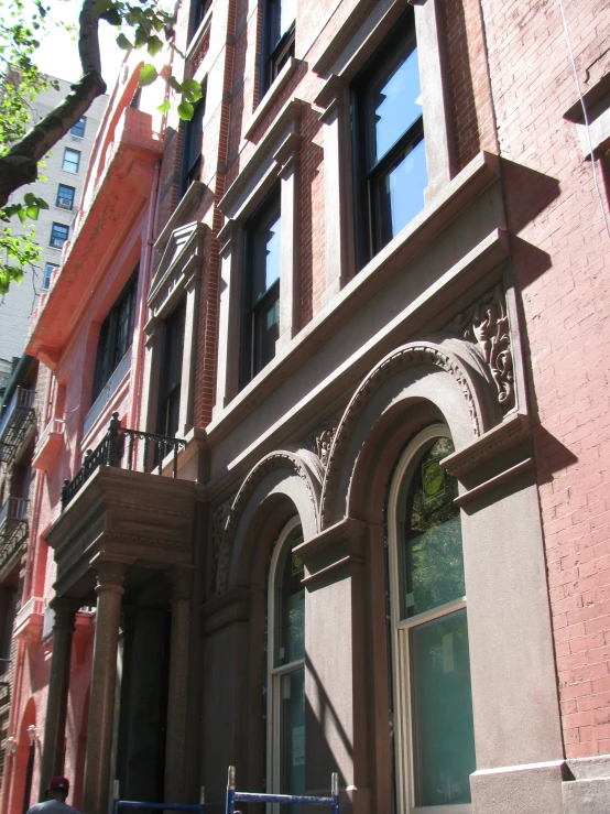 some brown buildings and trees outside and one is pink