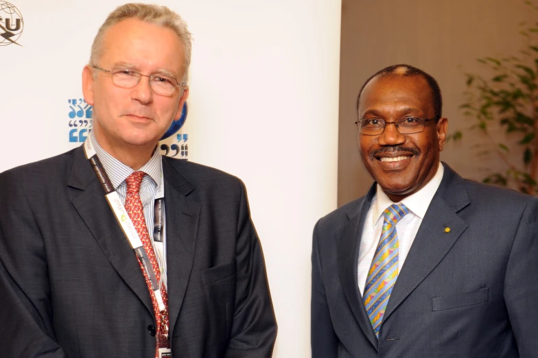 two men in suits are smiling for the camera