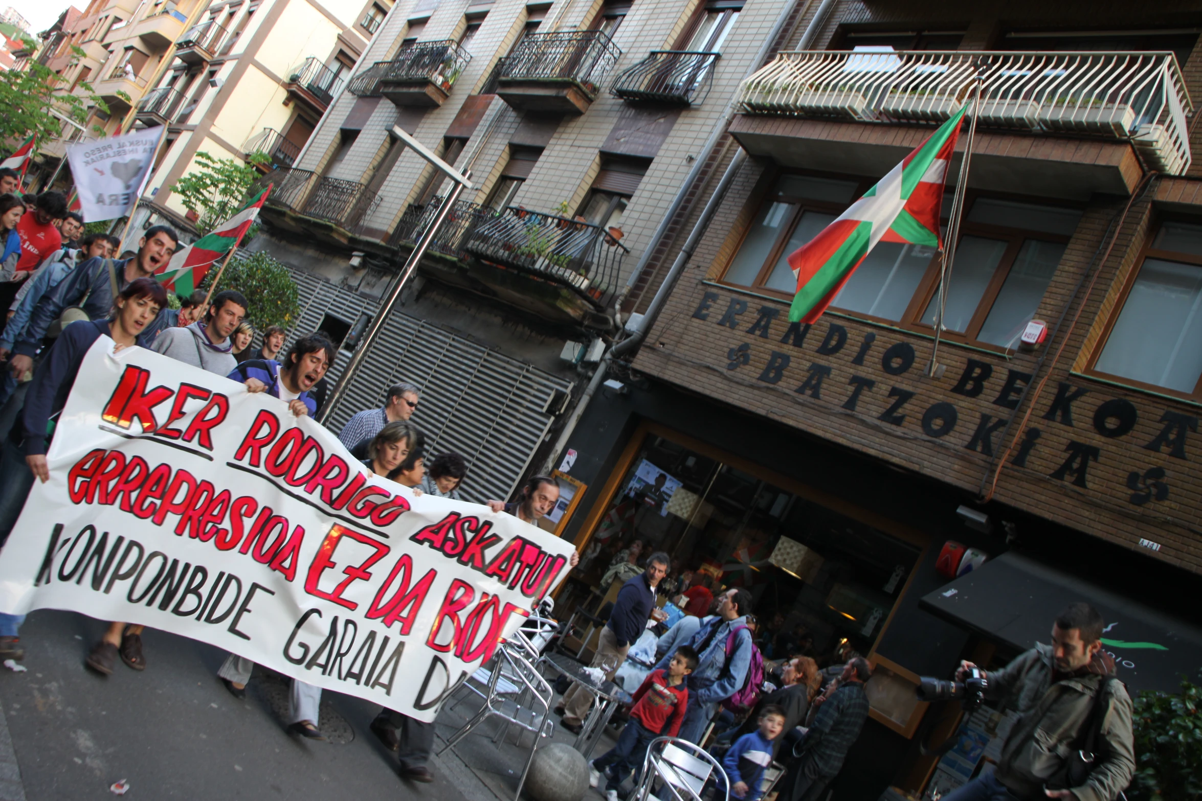 a group of people walking down the street carrying signs