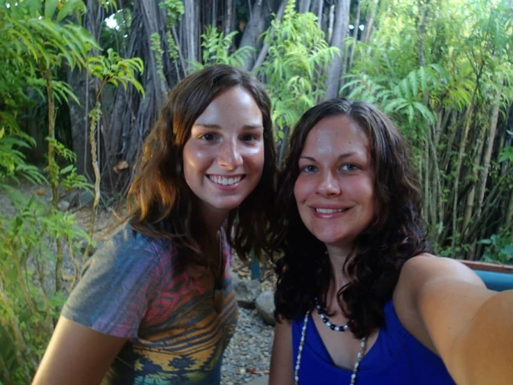 two young women taking a selfie on a path in the forest