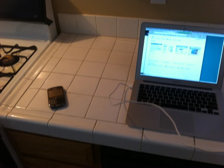 a laptop computer on a counter in a kitchen