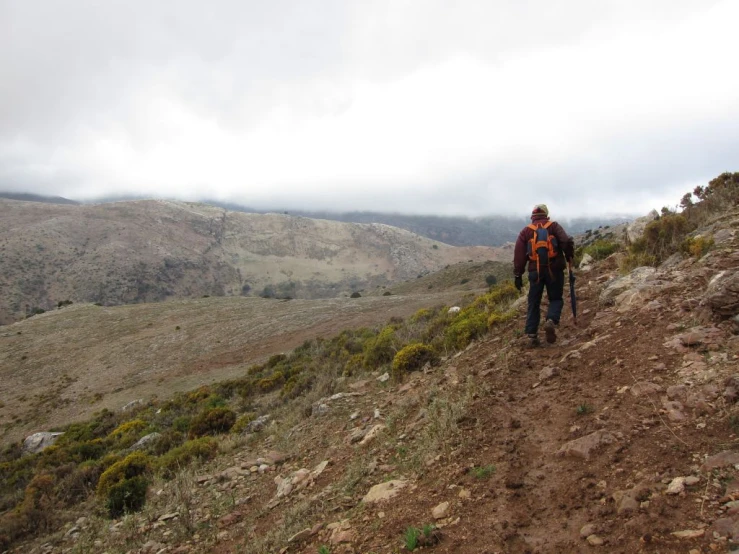 a man hiking along side of a dirt road