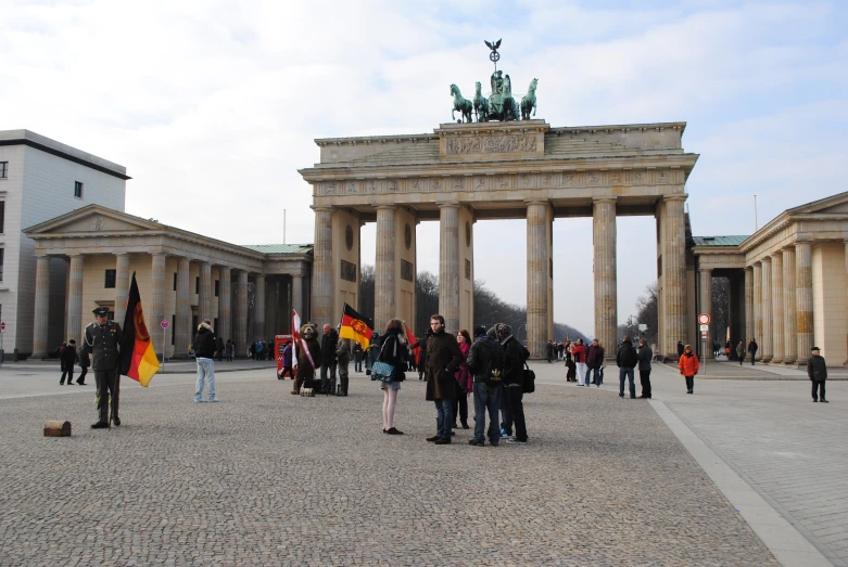 several people gathered at the entrance to an arch