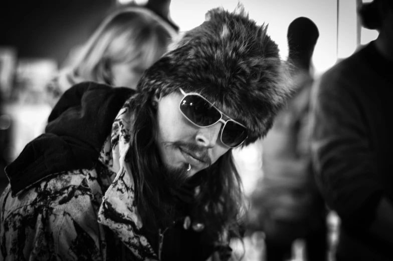 a man wearing sunglasses and a fur hat