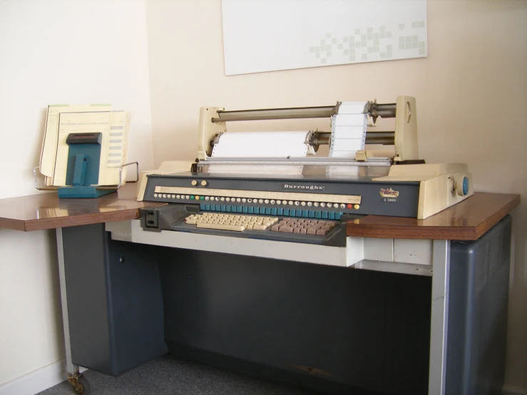 a desk with an old - fashioned computer, keyboard and printer