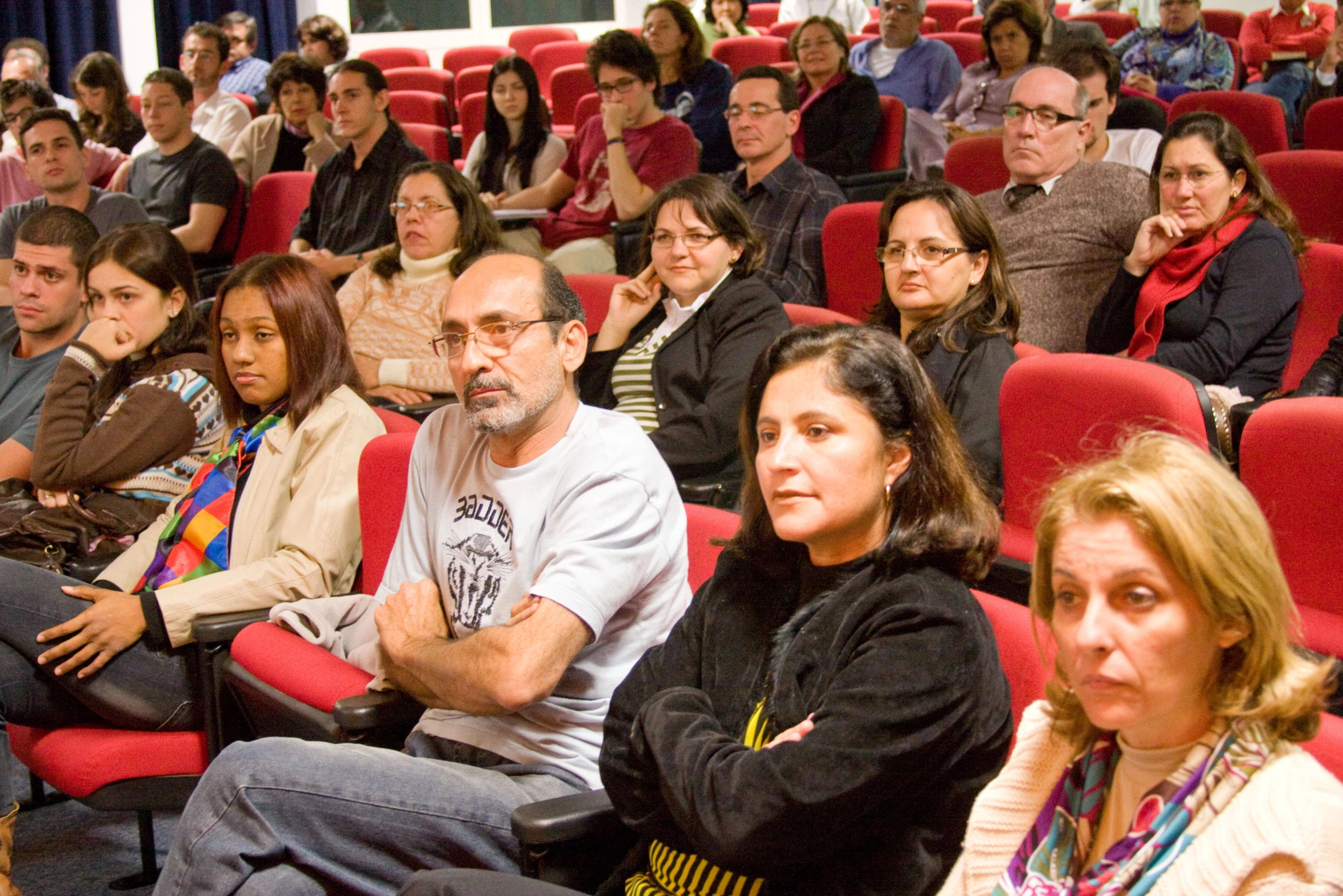 an audience in a lecture hall watching a man