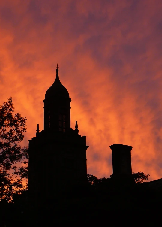 a clock tower is silhouetted against a twilight sky