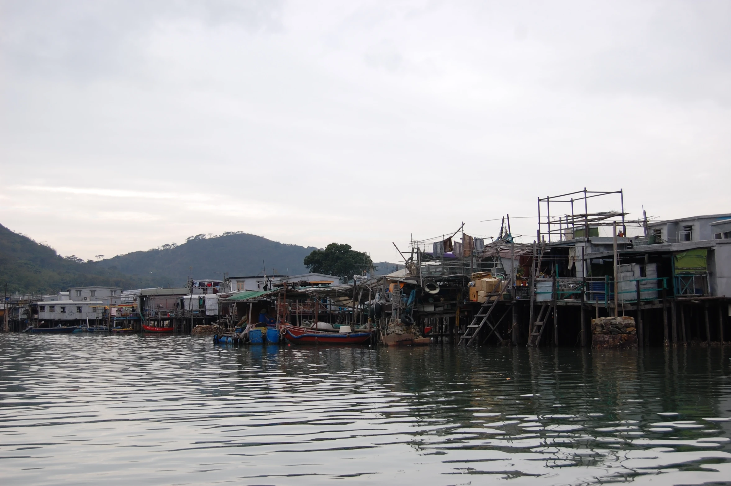 people walking up to shacks and standing on the water