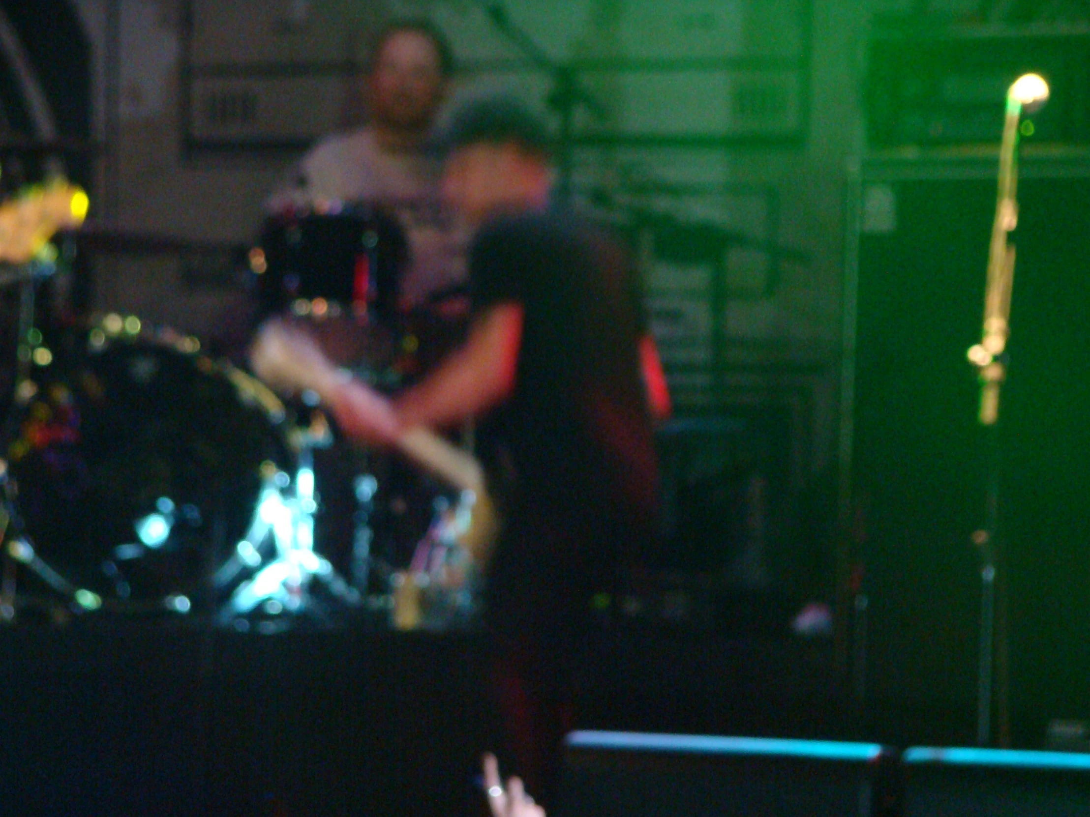 three men on stage playing instruments and lights