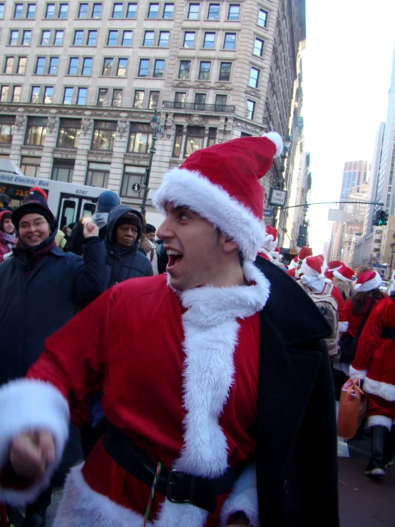 there are many people walking on the street wearing santa costumes