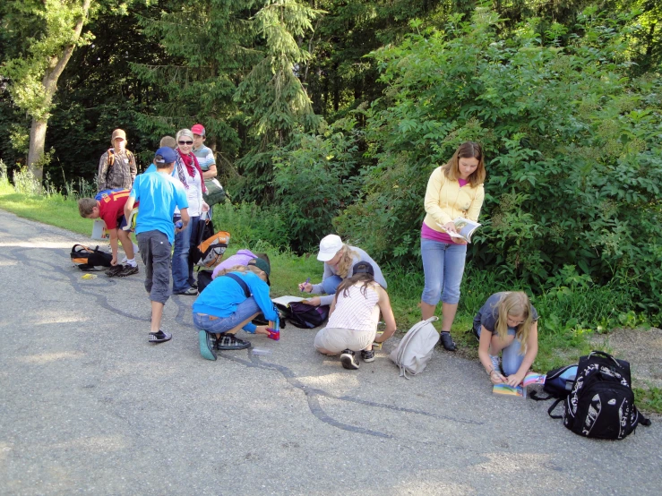 some people are kneeling and cleaning up bags