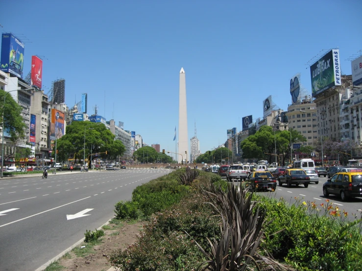 a view of a street with traffic, buildings and trees on each side