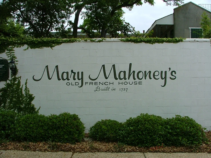 a white sign that reads mary mahoney's with trees on the side