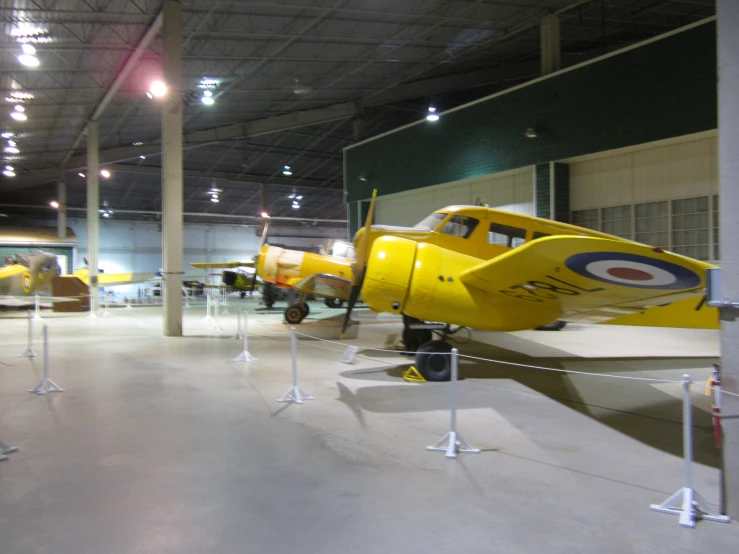 yellow airplanes are in a hangar with lights on