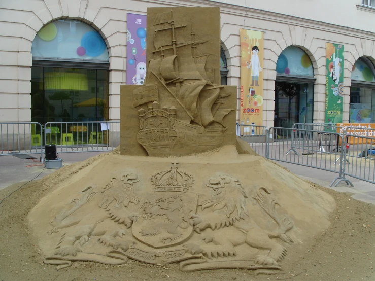 a large sand sculpture that is in front of a building