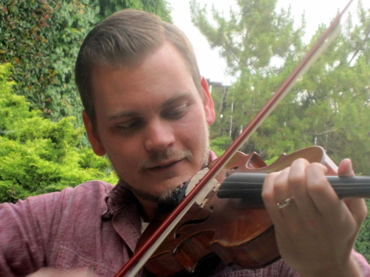 a man is playing a violin outside