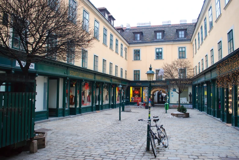 a view down a cobblestone street next to shops