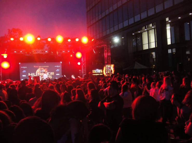 a large crowd is standing in front of a stage