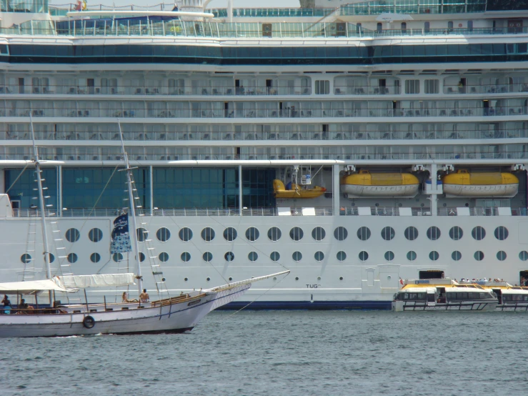 a white cruise ship and smaller boats on the water